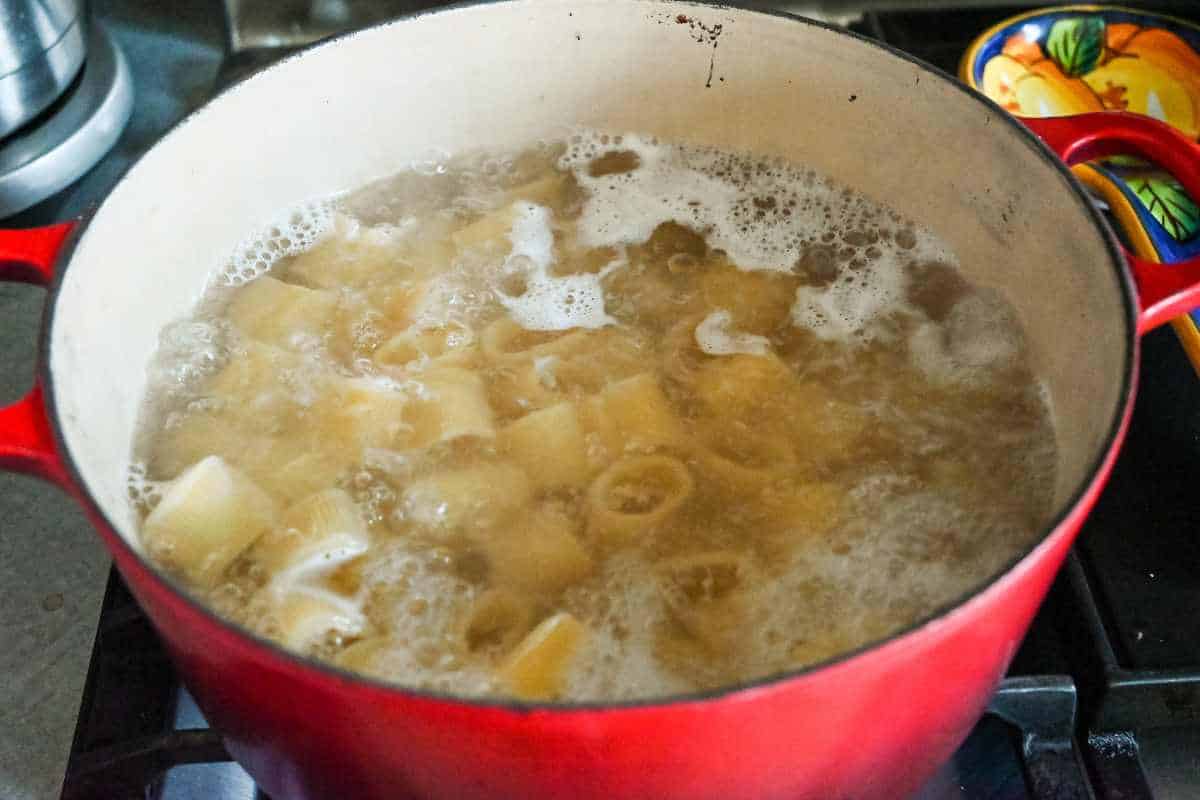 pasta boiling on the stove in a red pot.