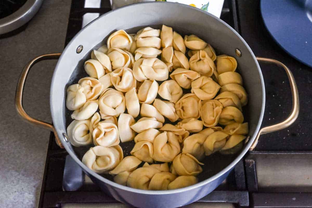 tortellini cooking in a pot on the stove.