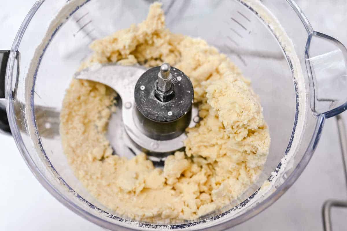 pie crust dough looking like wet sand in a food processor.