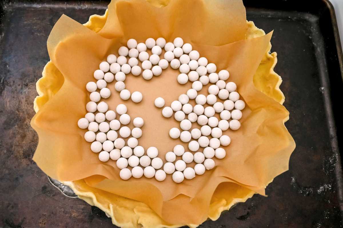 pie weights on top of parchment paper on top of pie crust.