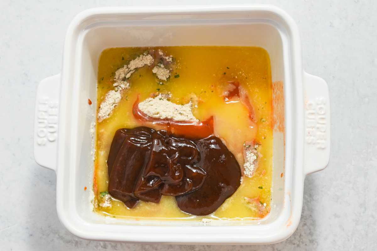 ingredients for buffalo wing sauce in a white square dish.