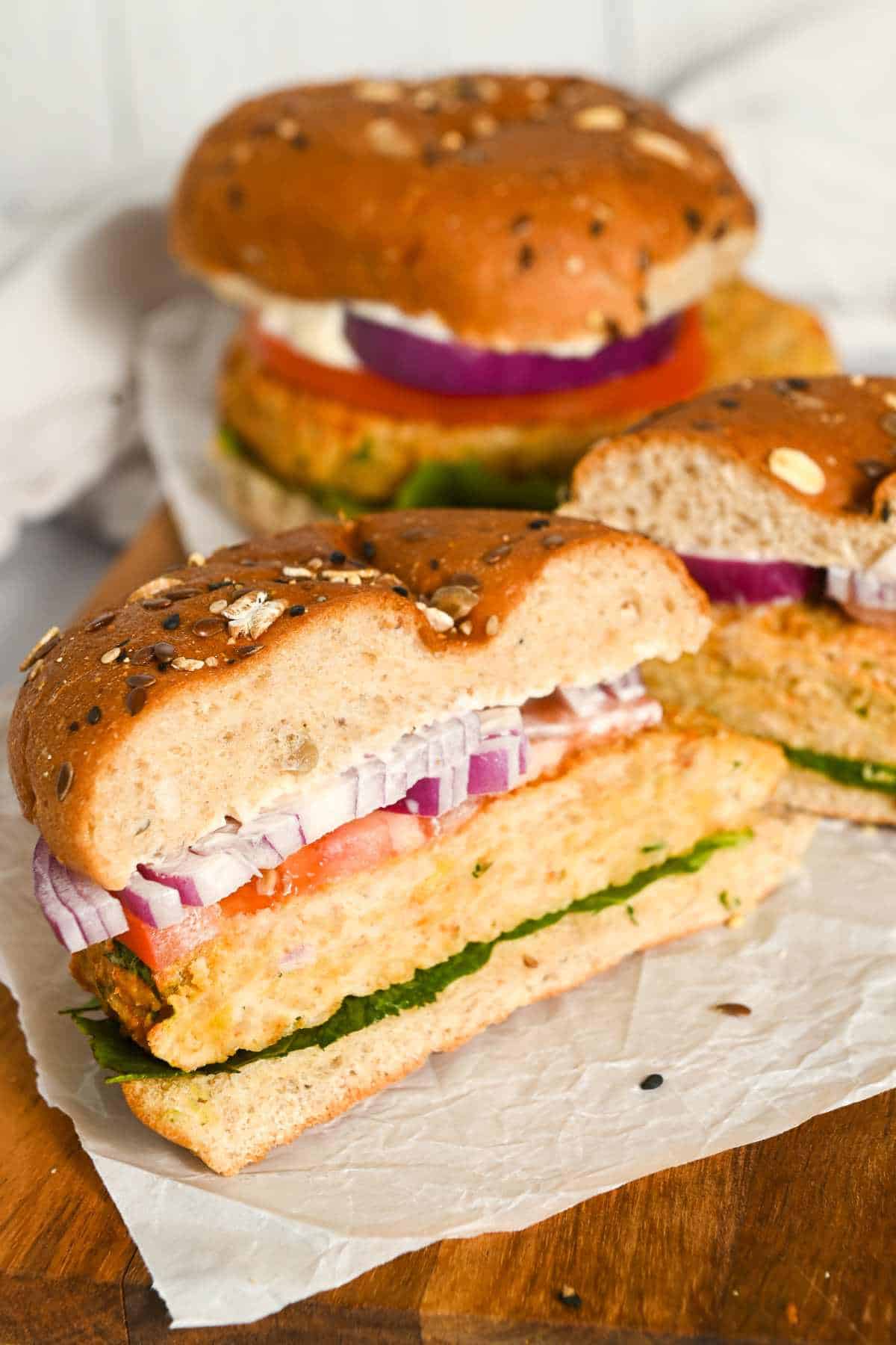 two air fryer chicken burgers with one cut in half, showing the inside.