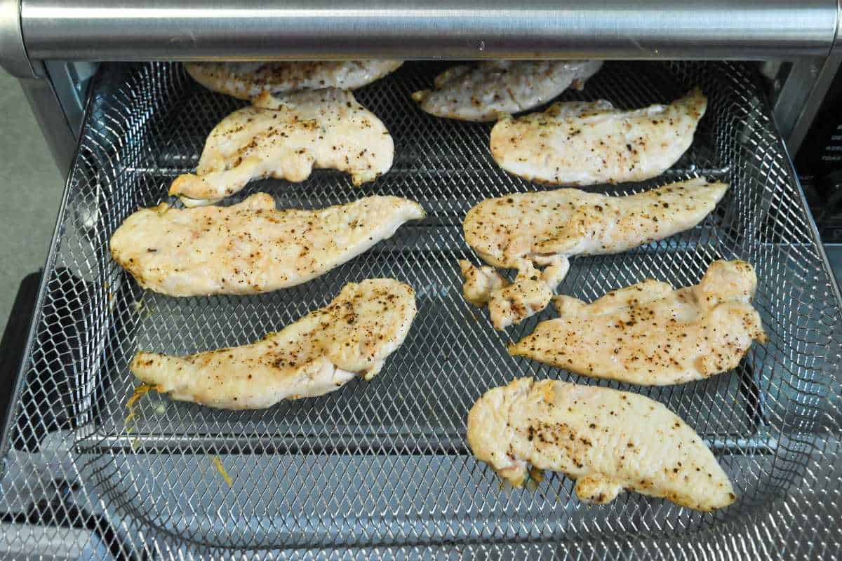 cooked chicken tenders on an air fryer tray.