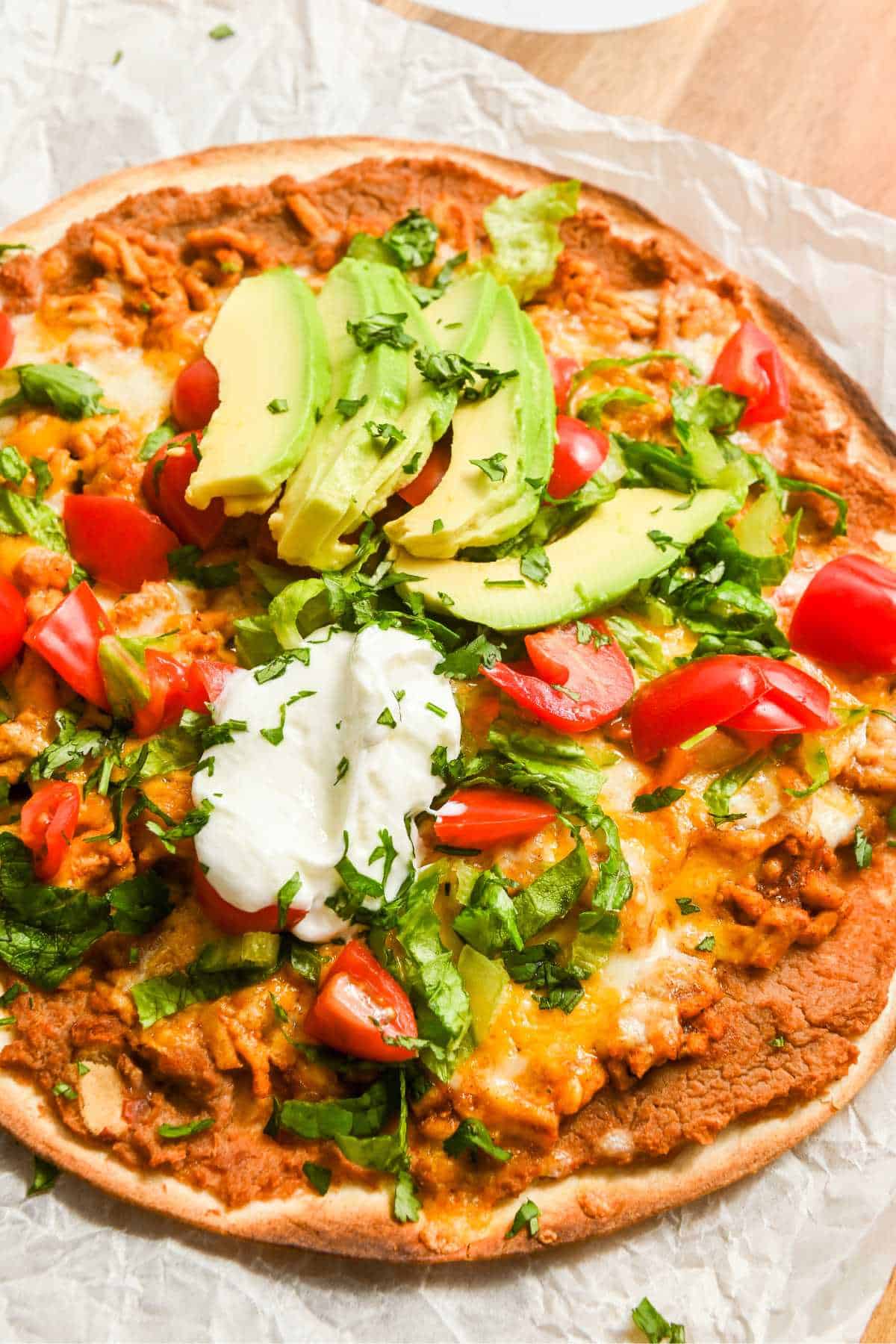 Mexican pizza topped with traditional taco toppings.