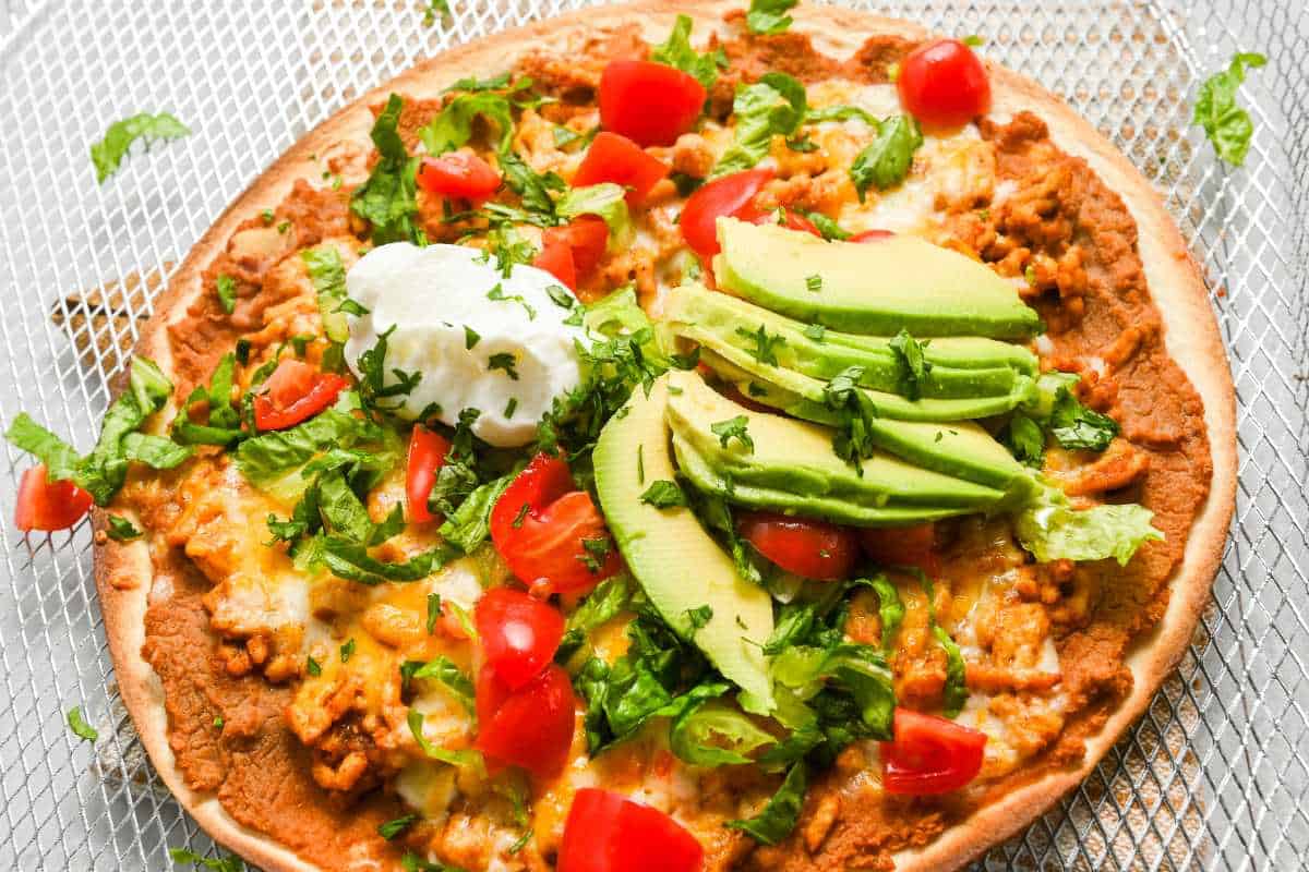 close up of Mexican pizza topped with traditional taco toppings.