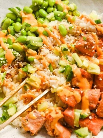 close up of a teriyaki salmon bowl with chopsticks.