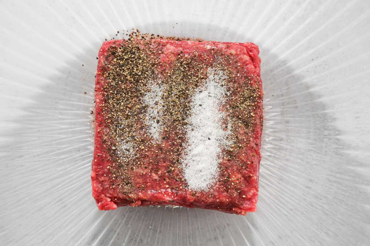 seasoned hamburger meat in a glass bowl.