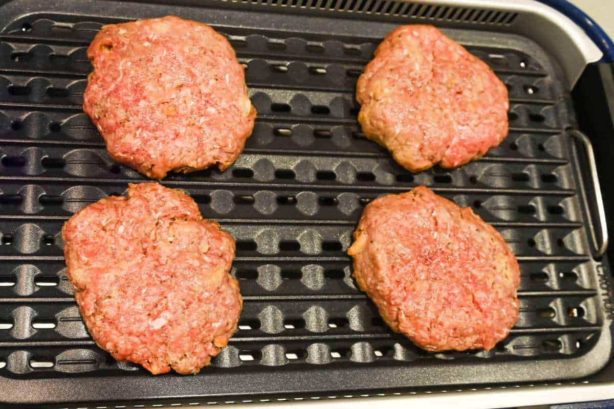 burger patties cooking on a grill.