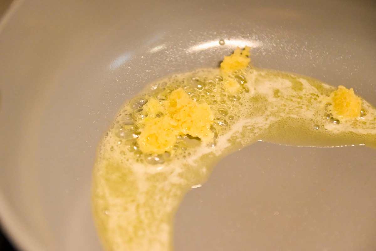 sauteeing garlic in butter in a pan.