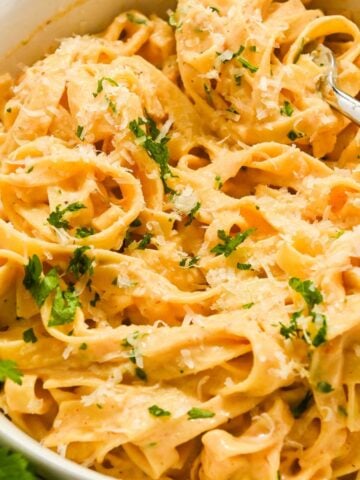 close up of cajun pasta fettuccine topped with parsley.