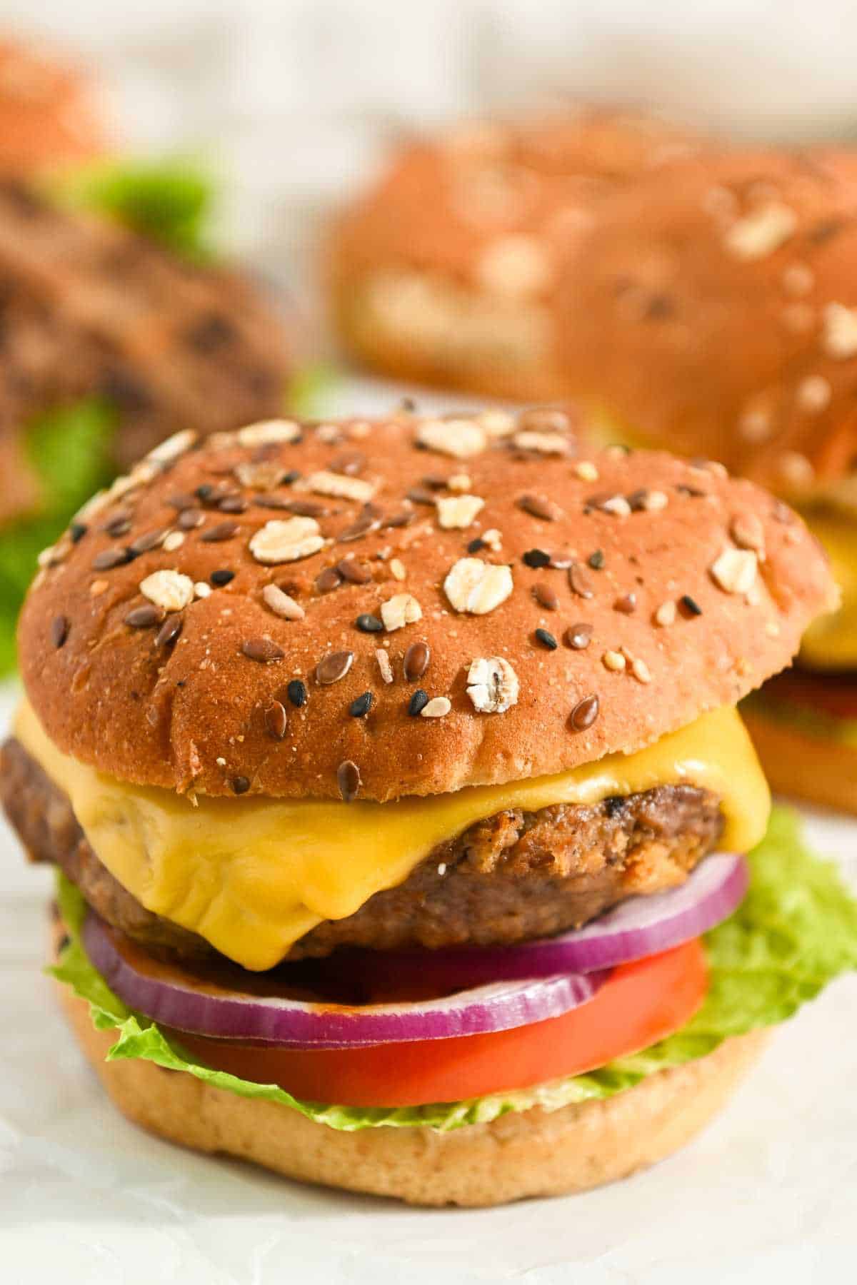 top down view of pub burger made with worcestershire sauce on a seeded bun with american cheese, lettuce, tomato, and red onion.