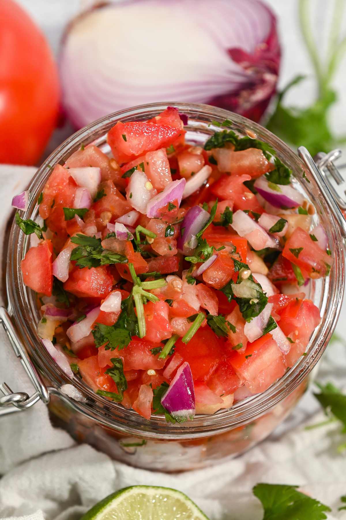 close up shot of mild pico de gallo in a glass jar.