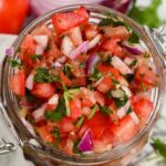 close up of mild pico de gallo salsa in a glass jar.