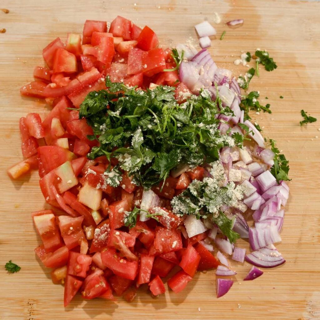 mild pico de gallo ingredients on a wooden cutting board.