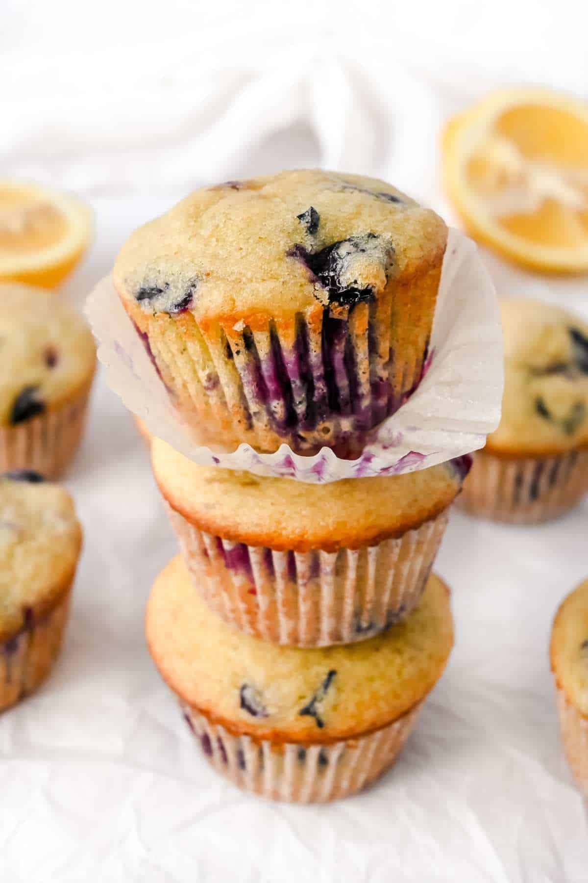 stack of 3 blueberry lemon protein muffins on a white background. 