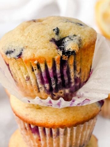 close up shot of blueberry lemon muffin with liner unwrapped.