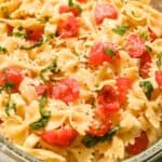 square featured photo of bow tie caprese pasta salad with parmesan, cherry tomatoes, and basil.