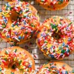 two funfetti donuts on a cooling rack.