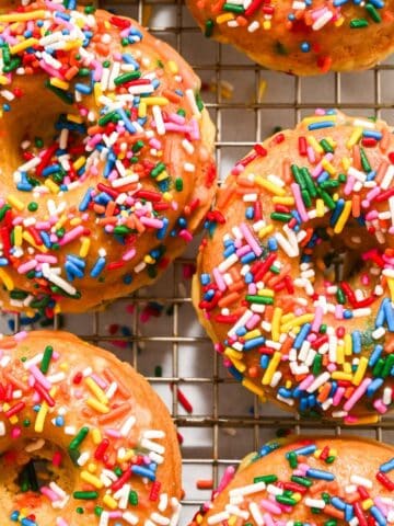 two funfetti donuts on a cooling rack.