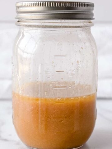 half filled jar of red wine vinaigrette.