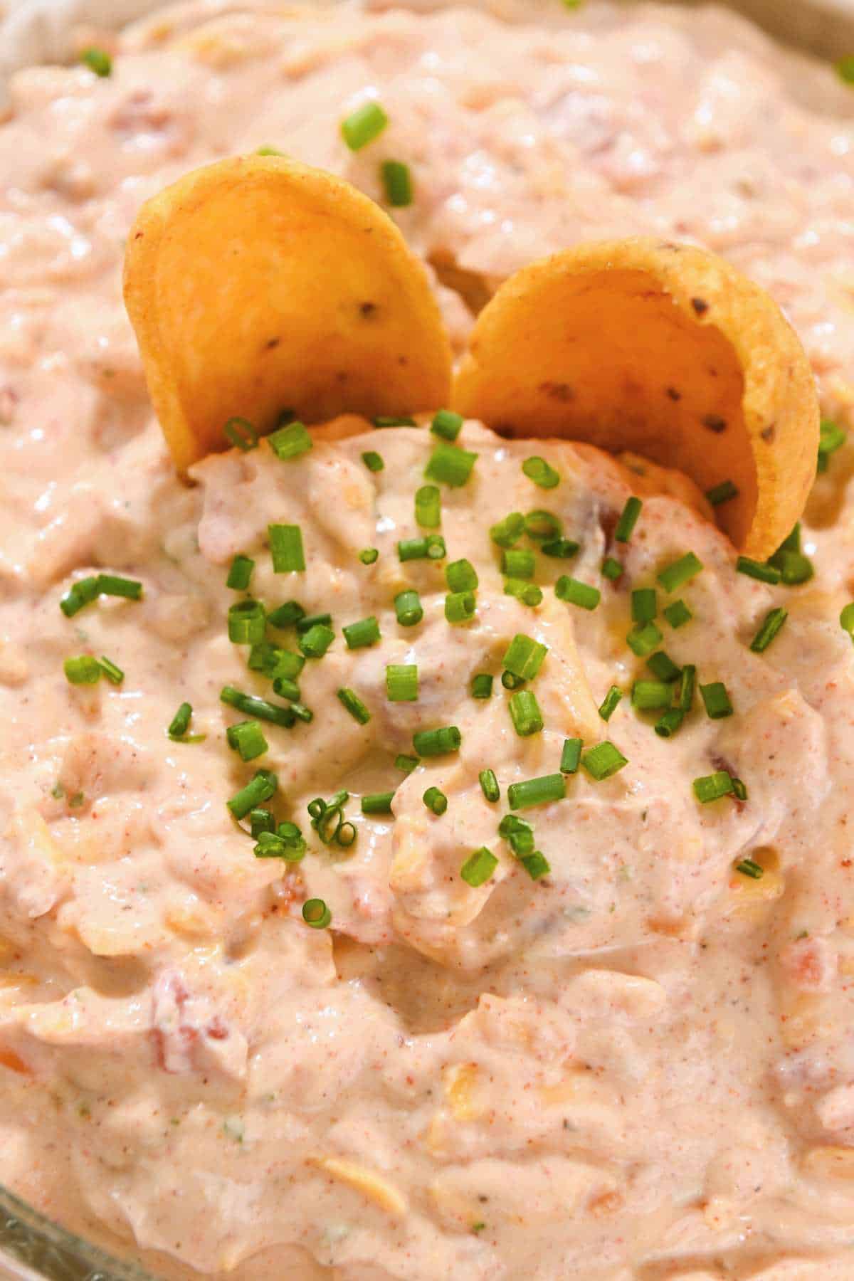 close up shot of pool dip with two fritos and chives.