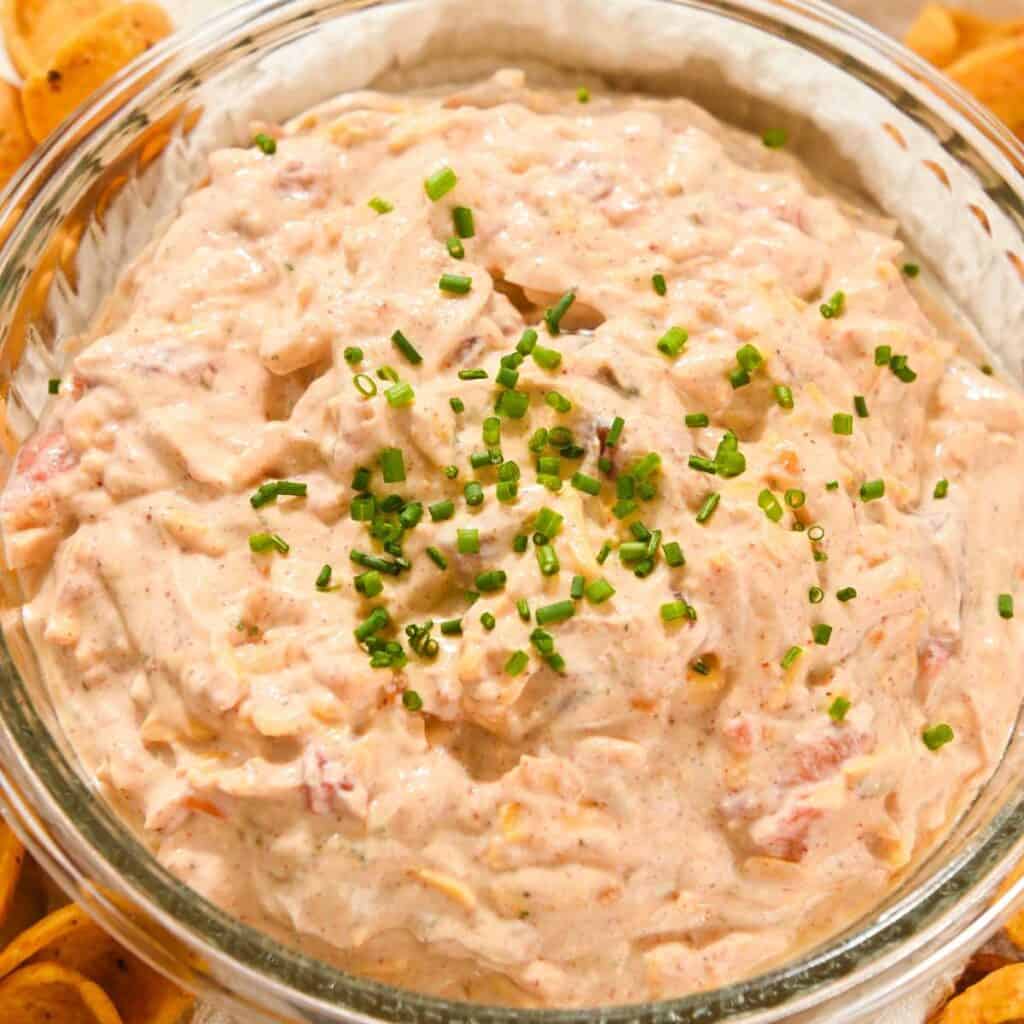 close up photo of creamy pool dip in a glass bowl topped with chives.