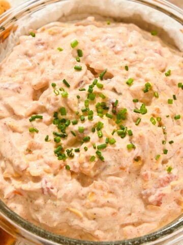 close up photo of creamy pool dip in a glass bowl topped with chives.