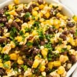 square photo of closeup shot of corn, black bean, and feta dip.