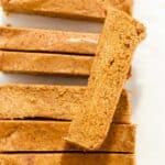close up shot of a pumpkin protein bar on top of other pumpkin protein bars.
