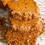 close up of three slices of pumpkin walnut bread laying on a wire rack.