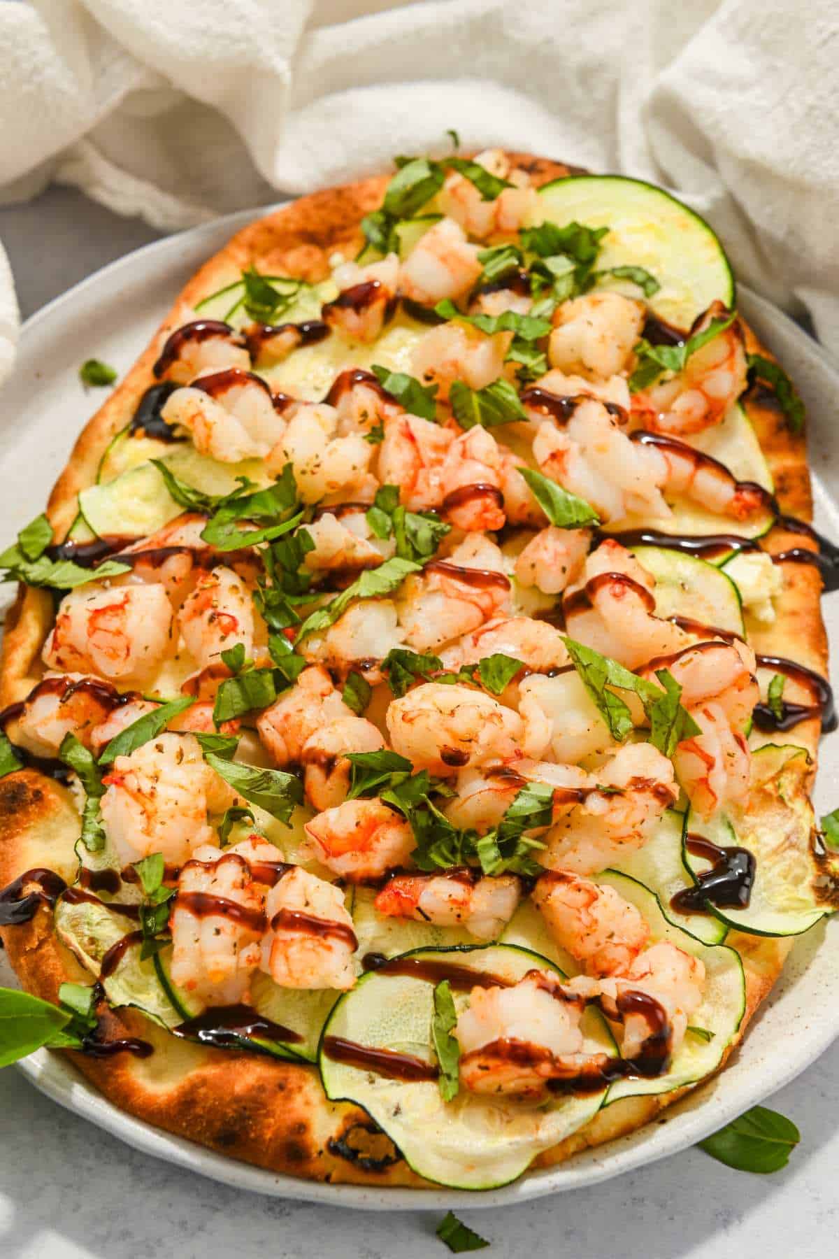 full air fryer shrimp pizza topped with balsamic glaze and fresh herbs.