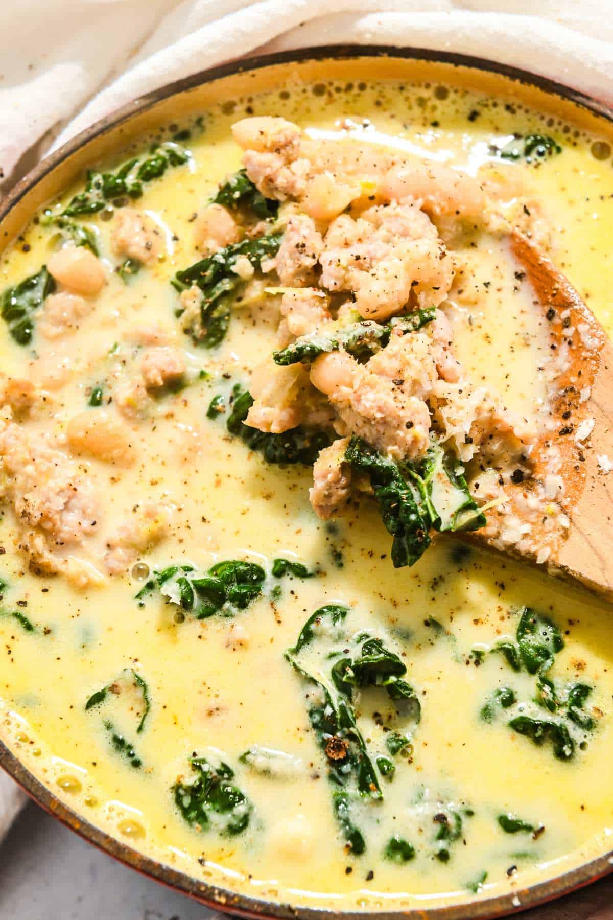 Full shot of creamy kale soup with a wooden spoon.