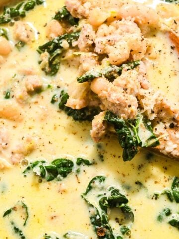 close up of creamy kale soup with beans and sausage.