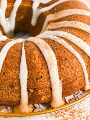 close up of pumpkin applesauce cake with a cream cheese frosting glaze.
