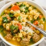close up of Instant Pot wedding soup in a white bowl with a spoon in it.