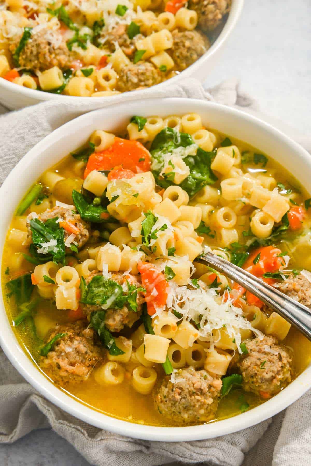 Instant Pot wedding soup in a white bowl with a spoon.