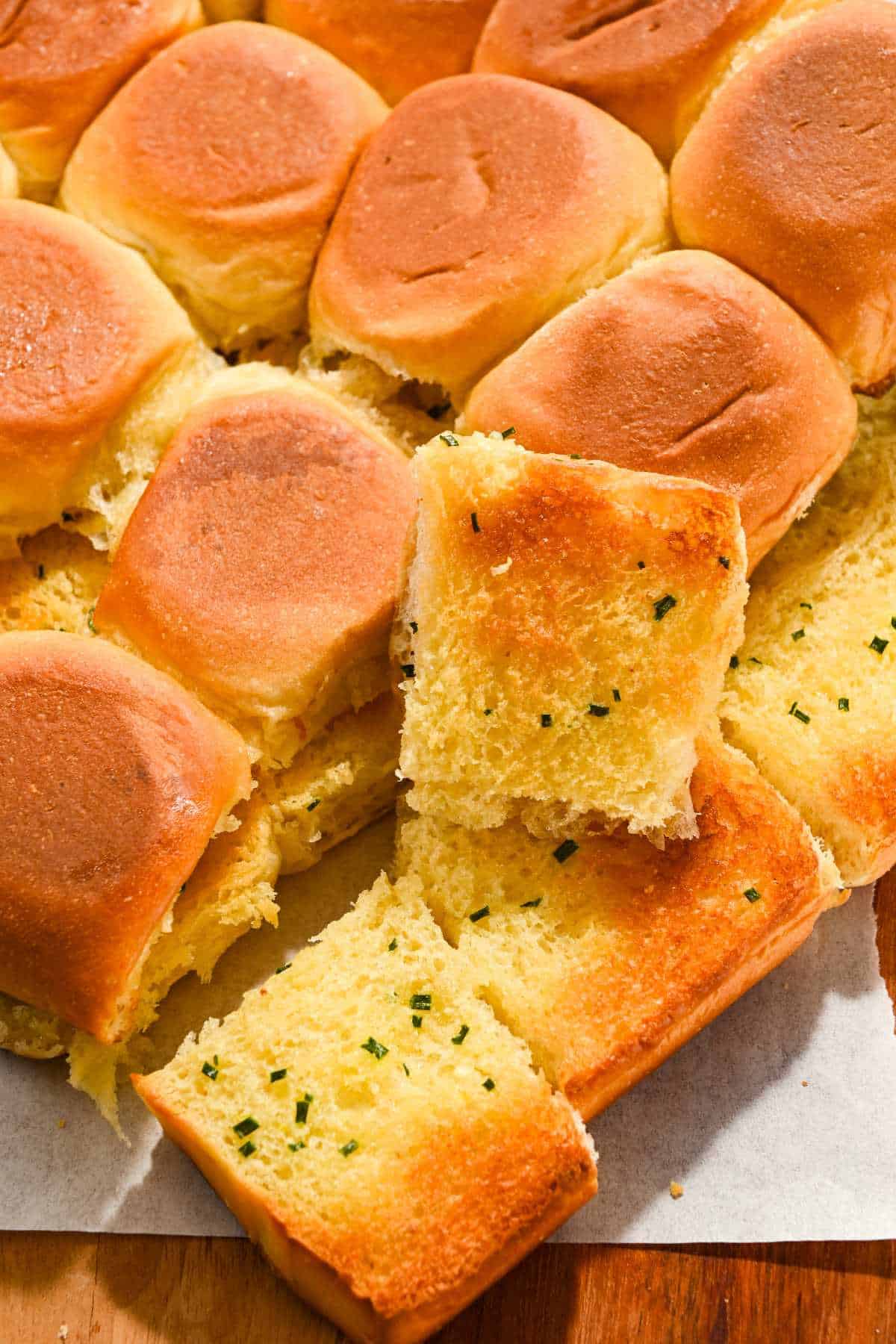Hawaiian roll garlic bread on a piece of parchment paper.