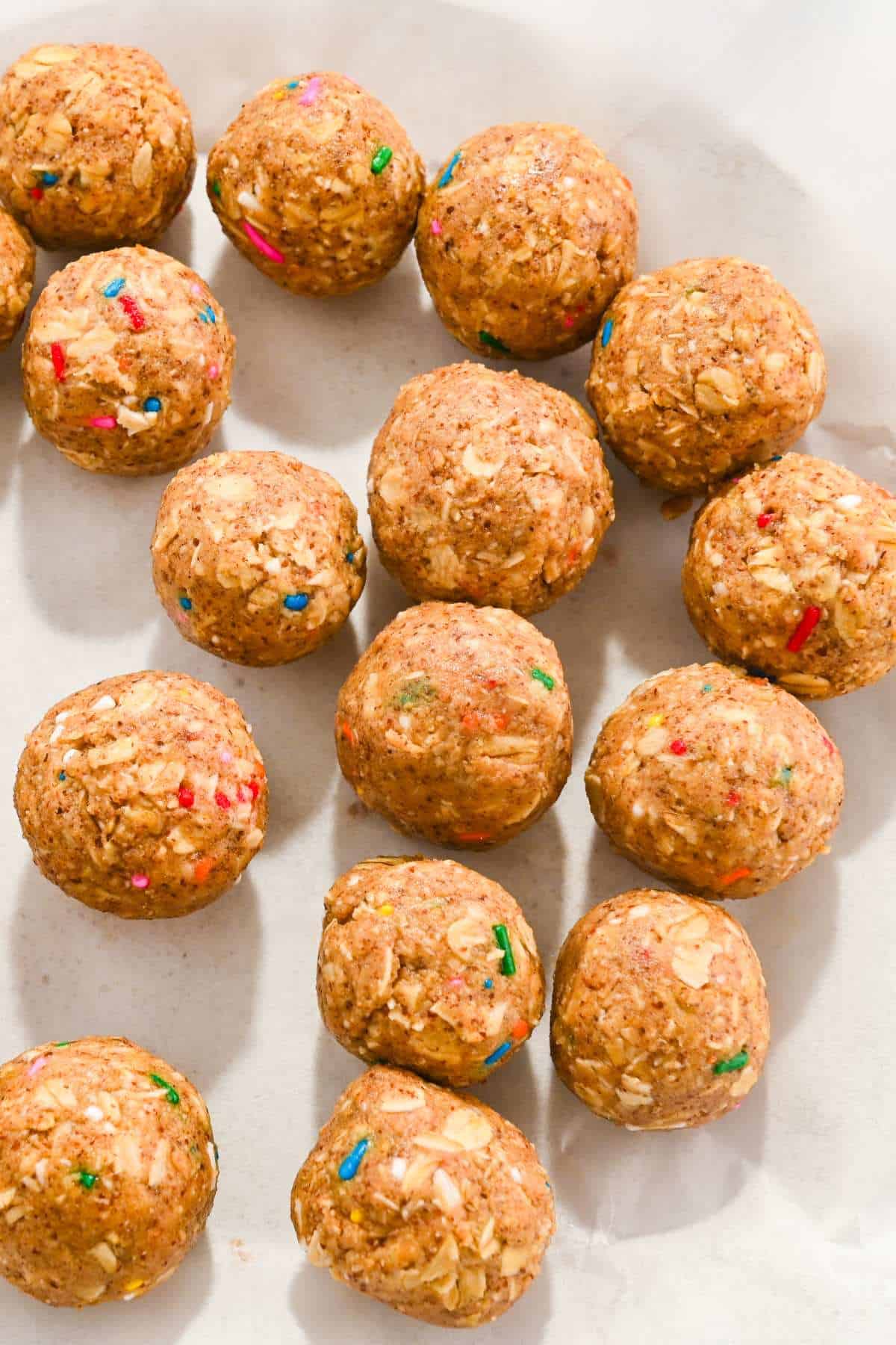 birthday cake protein balls on a white plate.