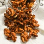 close up of candied Christmas walnuts in a mason jar.