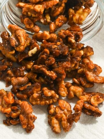 close up of candied Christmas walnuts in a mason jar.