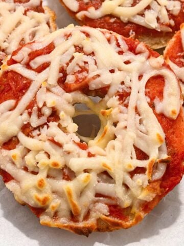 close up of air fryer bagel bites on a white background.
