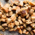 square photo of close up on homemade sourdough croutons on parchment paper.