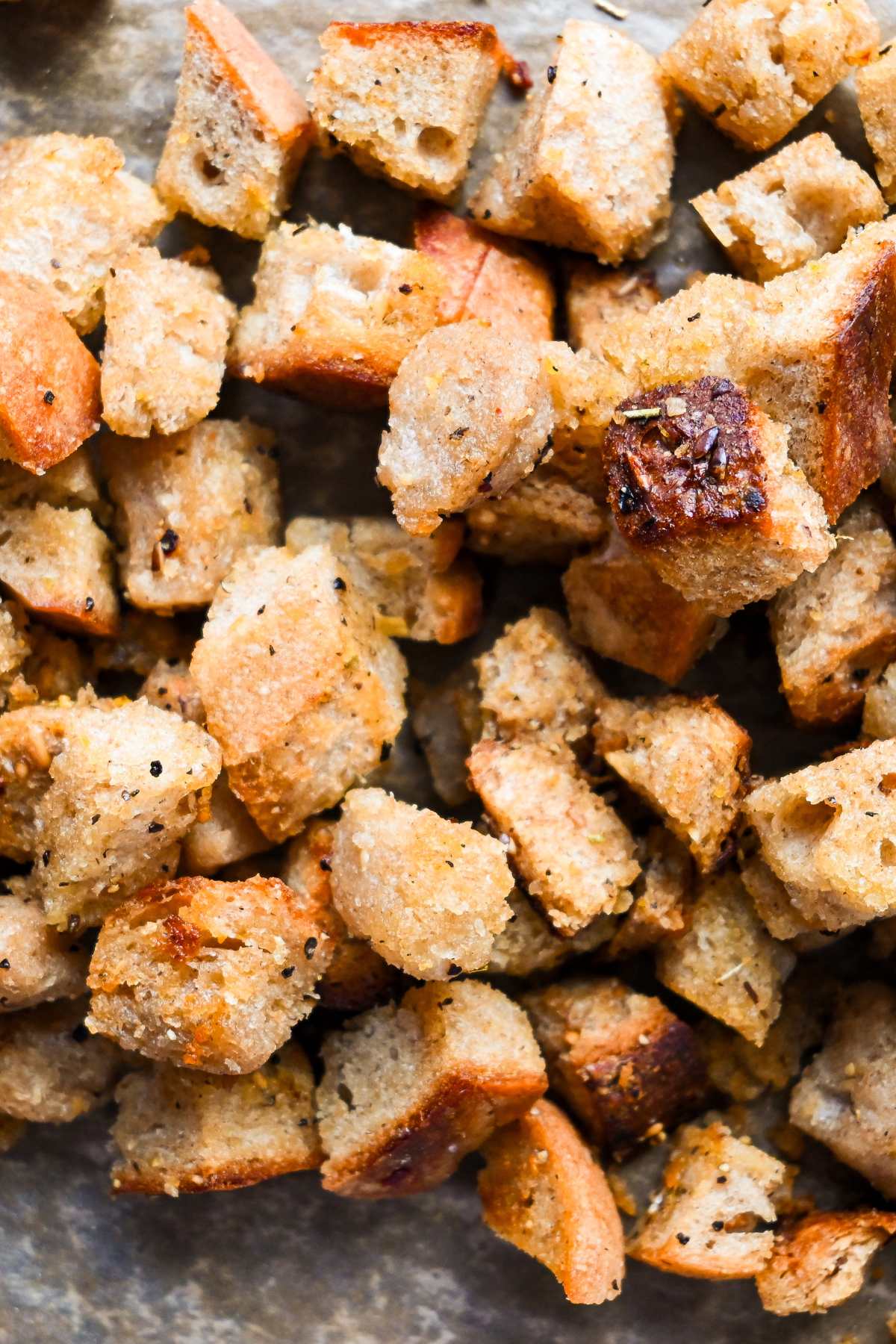 close up on homemade sourdough croutons on parchment paper.