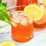 close up of an arnold palmer iced tea lemonade with ice in a glass with a lemon.