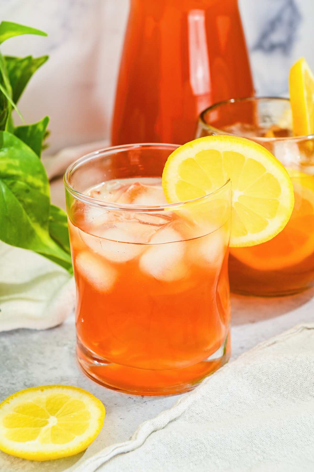 iced tea lemonade in a glass with a lemon on the rim.