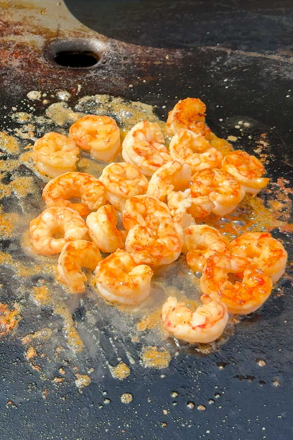 Shrimp cooking in sizzling butter and lemon juice on the Blackstone griddle.