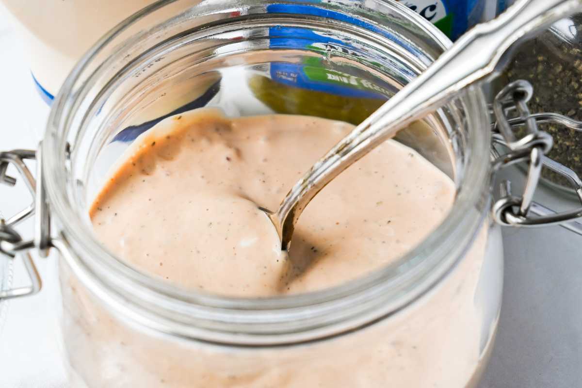 creamy homemade burger sauce in a glass jar with a spoon.