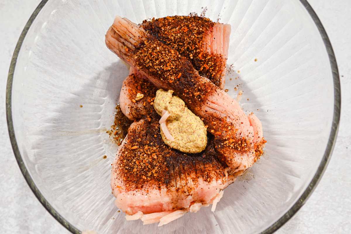 ground turkey in a bowl with burger seasoning, mustard, and Worcestershire sauce.