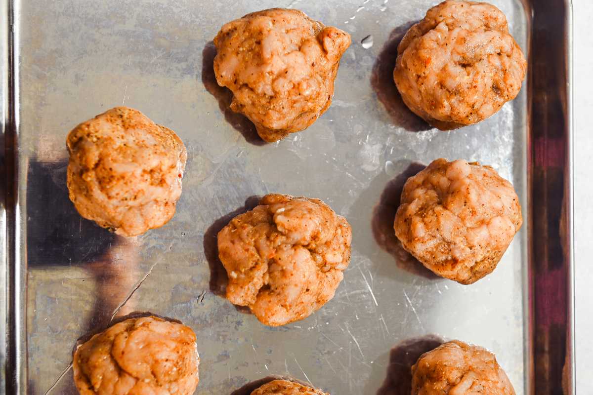seasoned turkey smash burger balls on a sheet pan.