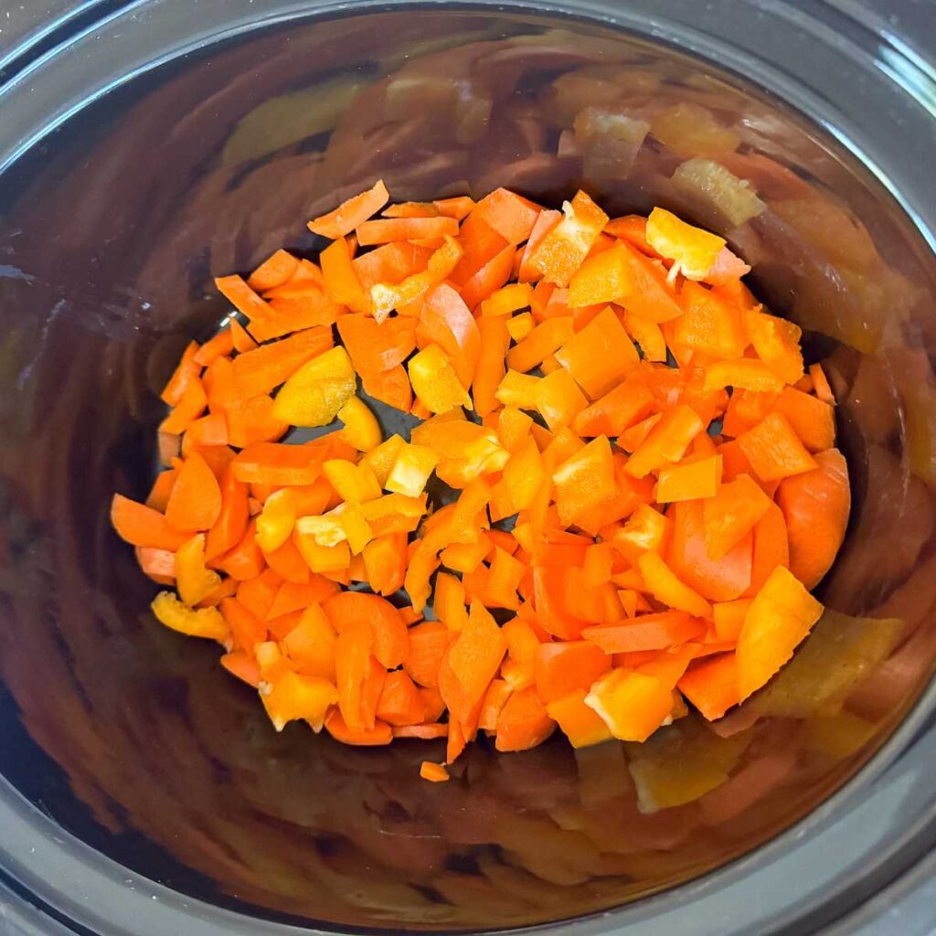 chopped peppers in a black crock pot.